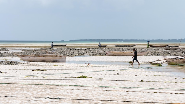 Personas y barcos en la playa de Zanzíbar .Tanzania