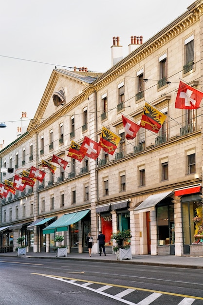 Personas en la calle Rue de la Corraterie con banderas suizas en el centro de Ginebra, Suiza.