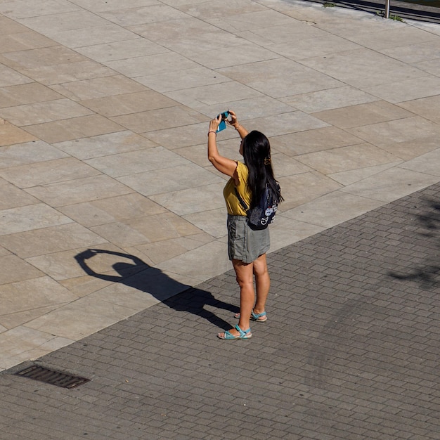 personas en la calle tomando fotos con un teléfono inteligente en la ciudad de Bilbao, España