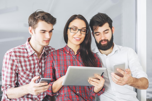 Personas caucásicas que usan tabletas y teléfonos inteligentes