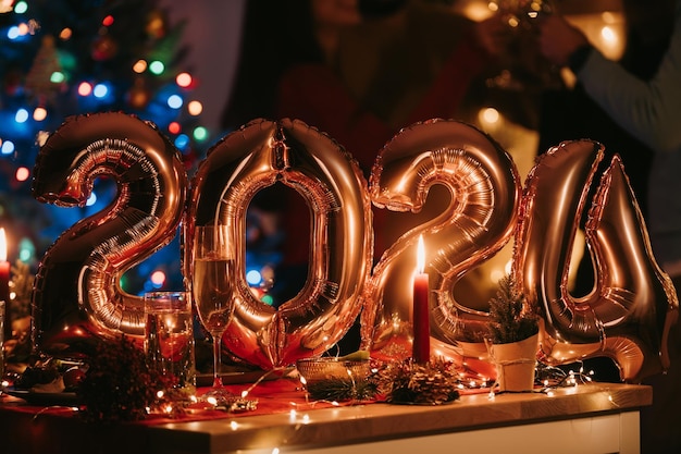 Personas celebrando el Año Nuevo mientras los globos dorados en forma de número 2024 se encuentran en el fondo