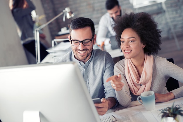 Personas creativas que trabajan en la oficina en la computadora