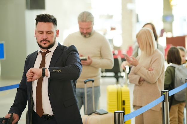 Personas con equipaje haciendo cola para registrarse en el aeropuerto