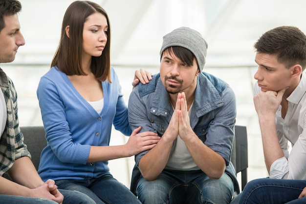 Las personas están sentadas en círculo y apoyándose unas a otras.