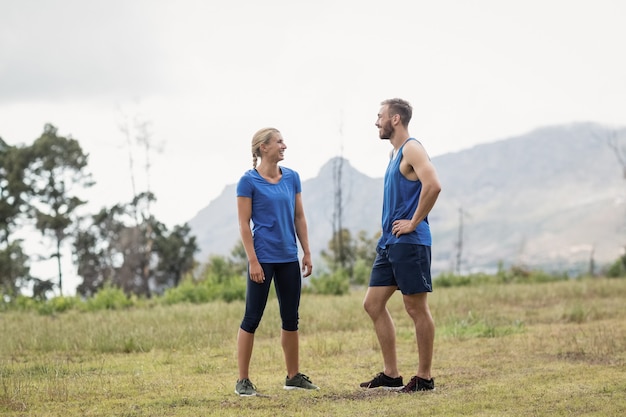 Personas en forma conversando en el campo de entrenamiento