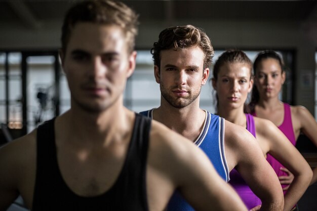 Personas en forma con las manos en las caderas en el gimnasio