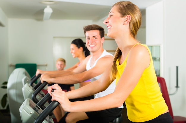 Personas en el gimnasio deportivo en la máquina de fitness