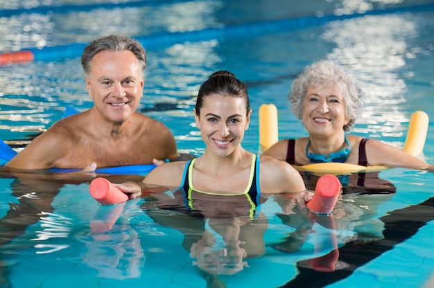 Foto personas haciendo ejercicio en una piscina.