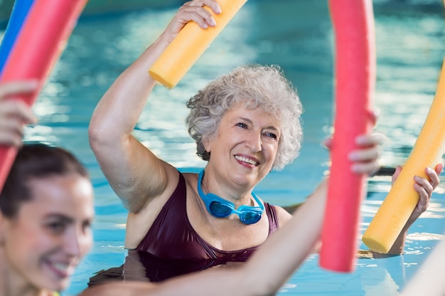 Foto personas haciendo ejercicio en una piscina.