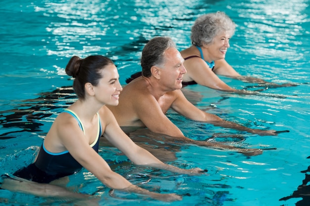 Personas haciendo ejercicio en una piscina.