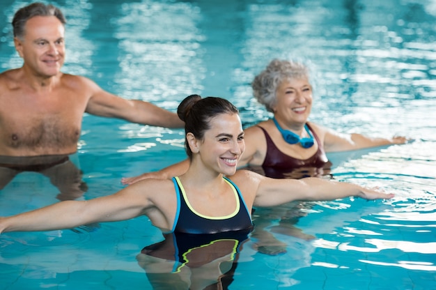 Foto personas haciendo ejercicio en una piscina.