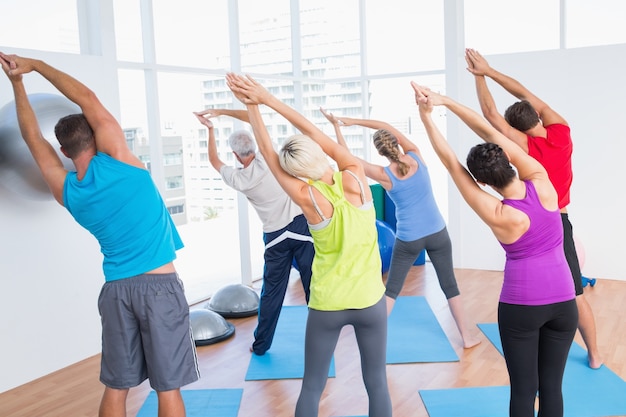 Personas haciendo ejercicios de estiramiento en clase de yoga