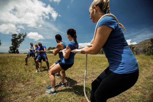 Personas jugando tira y afloja durante el curso de entrenamiento de obstáculos