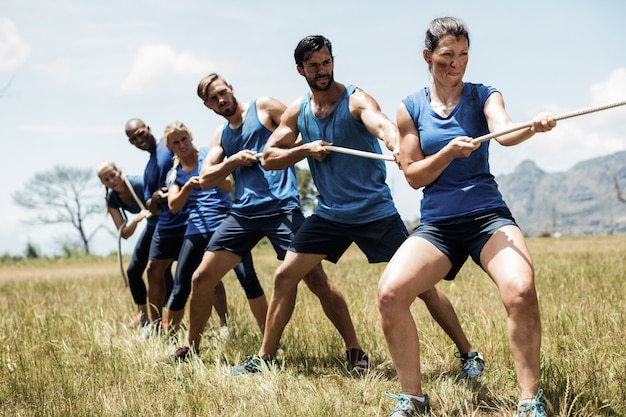 Personas jugando tira y afloja durante el curso de entrenamiento de obstáculos