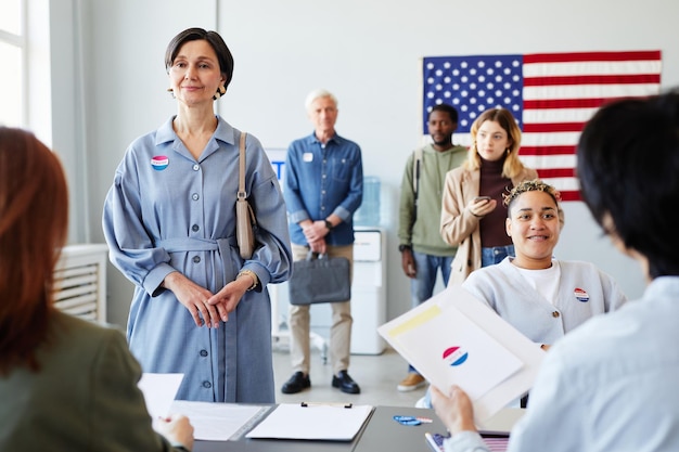 Personas en línea en la oficina de votación