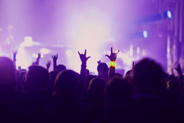 Personas con las manos en alto en la escena del concierto de entretenimiento de fiesta de evento.