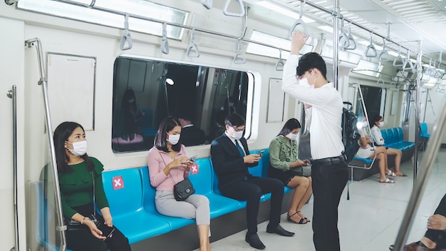 Personas con máscaras faciales en un tren subterráneo público abarrotado