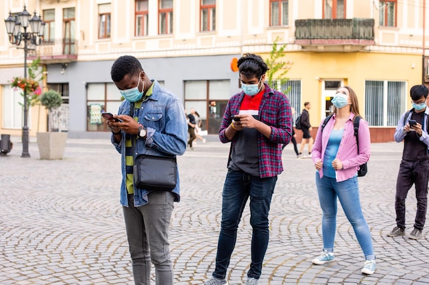 Personas con máscaras hacen cola manteniendo la distancia social