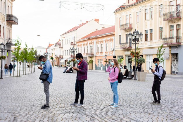 Personas con máscaras hacen cola manteniendo la distancia social