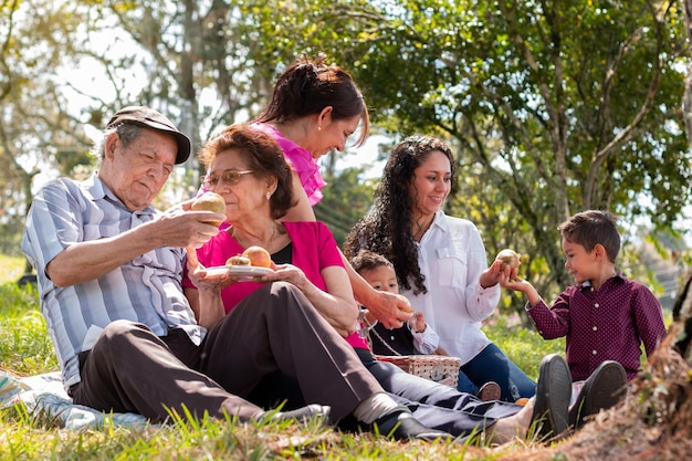 Personas mayores disfrutando de un día familiar en el campo con hijas y nietos sonriendo alegremente