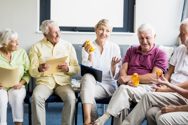 Personas mayores y enfermera con medicina