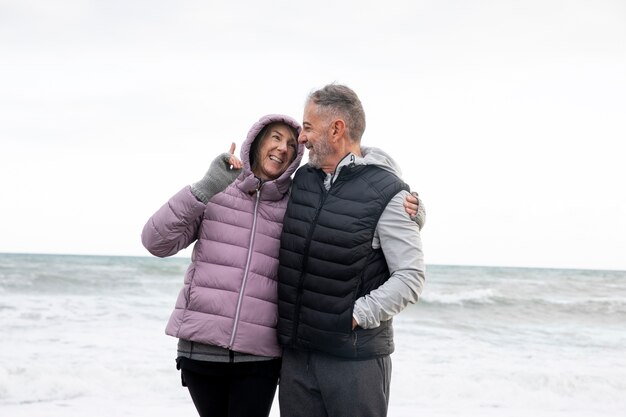 Foto personas mayores felices de tiro medio en la playa