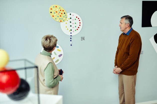 Foto personas mayores hablando de obras de arte