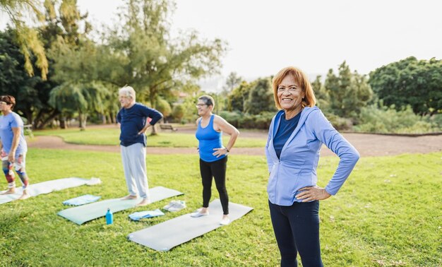 Personas mayores multirraciales haciendo ejercicios al aire libre con el parque de la ciudad en el fondo Estilo de vida saludable y concepto de estilo de vida alegre para personas mayores Enfoque en la cara de la mujer latina