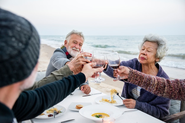 Personas mayores que tienen una cena en la playa