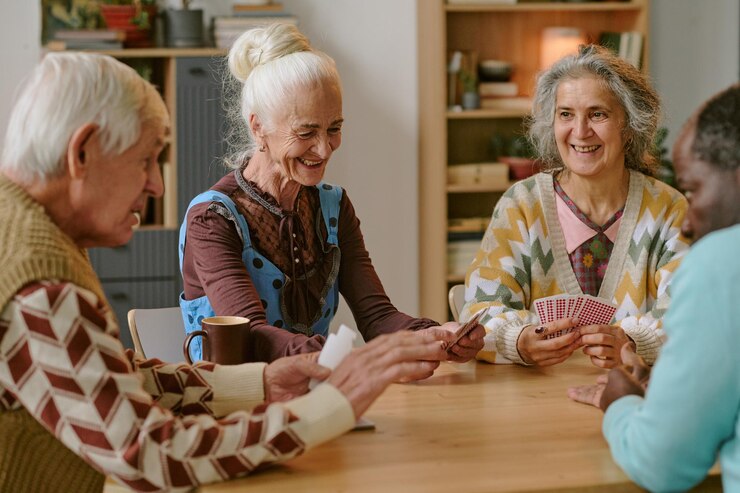 Personas mayores sonriendo y disfrutando jugando a las cartas juntos en el hogar de ancianos
