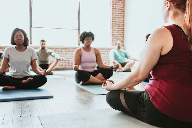 Personas meditando en una clase de yoga.