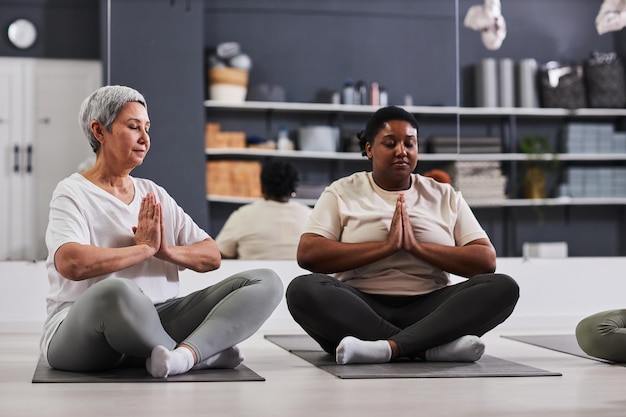 Personas meditando durante el entrenamiento deportivo.