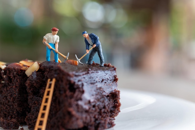 Personas en miniatura Un empleado está haciendo un brownie de chocolate