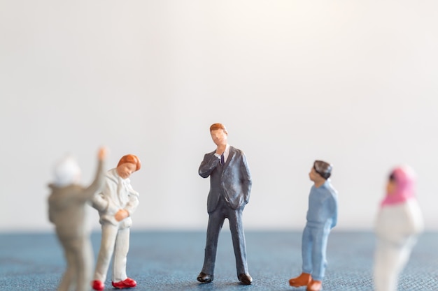 Personas en miniatura Estudiantes de pie con el profesor en el aula. Concepto del Día Mundial del Maestro