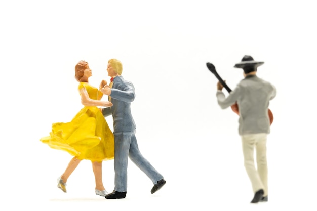 Personas en miniatura Pareja bailando con un guitarrista tocando la guitarra