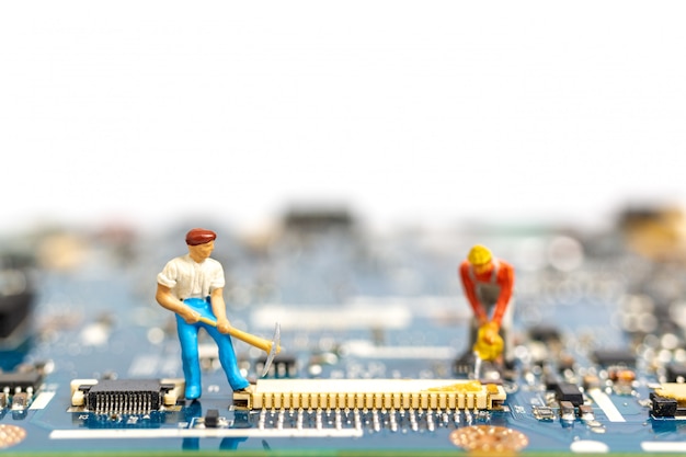 Personas en miniatura que trabajan en el tablero de la CPU