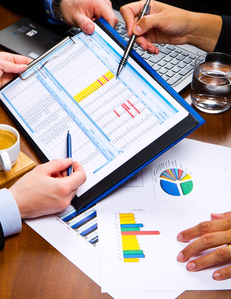 Personas de negocios discutiendo los gráficos y gráficos que muestran los resultados de su exitoso trabajo en equipo