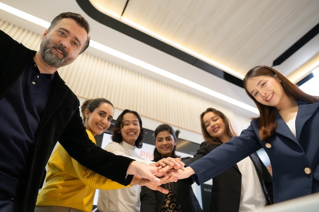 Foto personas de negocios poniendo sus manos juntas como símbolo de unidad y trabajo en equipo