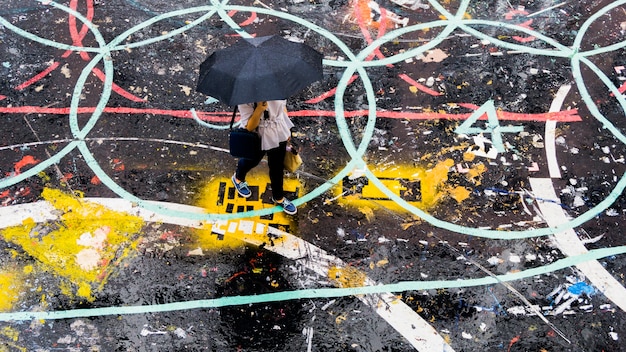 personas con paraguas camina en la calle peatonal en la vista aérea superior en la lluvia.