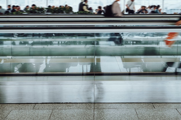 Personas en una pasarela móvil en una terminal de pasajeros en el aeropuerto