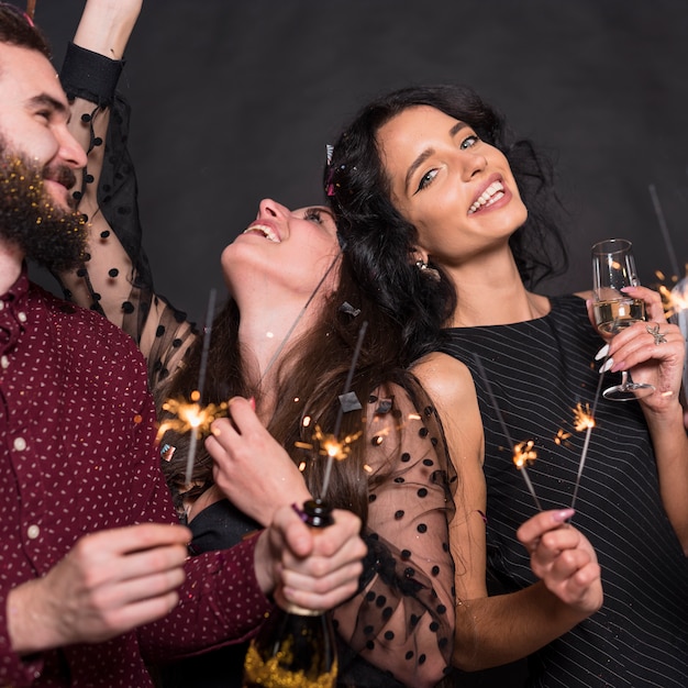 Foto personas de pie con bengalas encendidas en fiesta