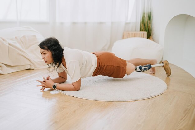 Personas con piernas protésicas entrenando tablones ejercicio en casa discapacidad mujer asiática actividad sanitaria interior