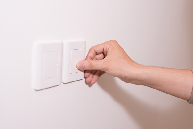 Personas presionando el botón de luz en la pared