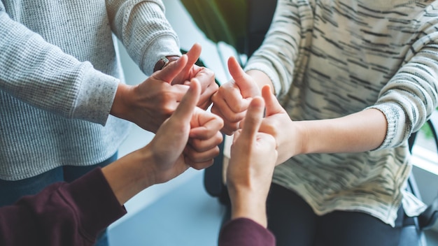 Las personas que hacen el pulgar hacia arriba firman las manos en círculo