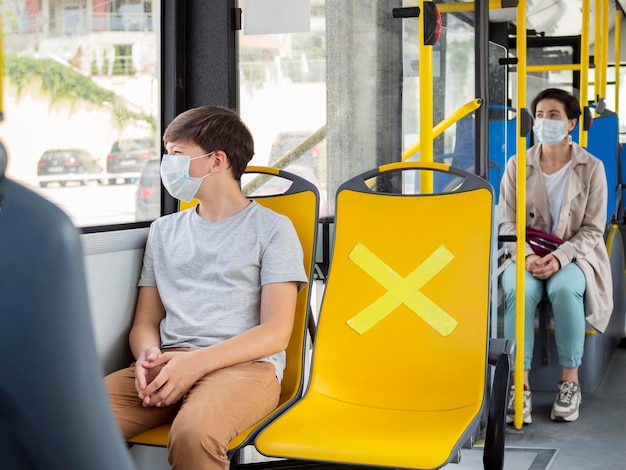 Foto personas que mantienen distancia social en autobús