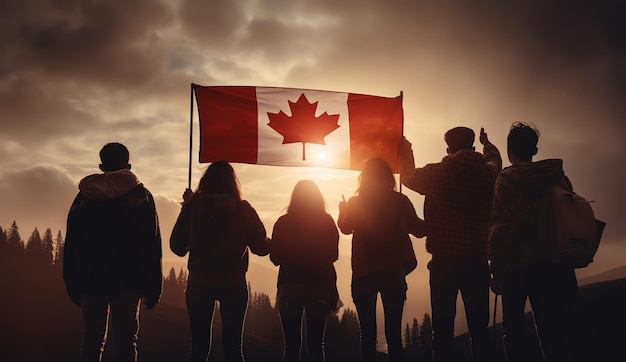 Personas que sostienen una bandera canadiense frente a una puesta de sol