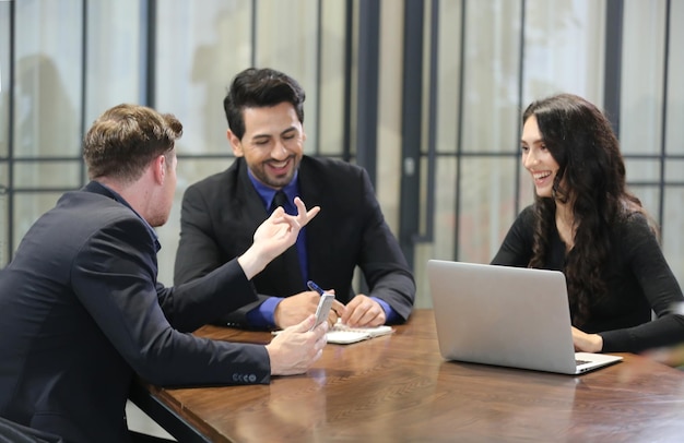 Personas que trabajan en nuevas empresas Dos personas de negocios sonriendo e intercambiando ideas mientras usan laptopxA