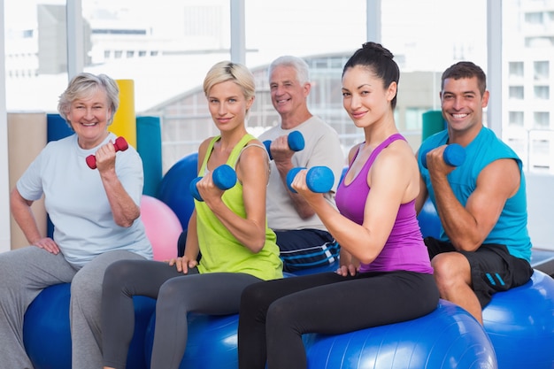 Foto las personas que trabajan con pesas en la clase de gimnasia