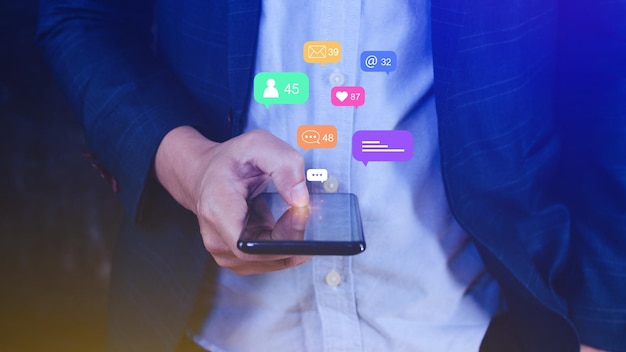 Personas que usan medios sociales y conceptos de marketing digital en línea en teléfonos móviles con íconos como comentarios de mensajes de notificación en la pantalla del teléfono inteligente