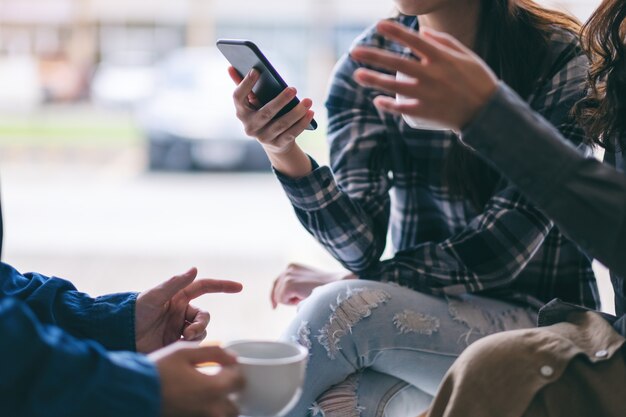 Personas que usan el teléfono, hablan y toman café juntos.